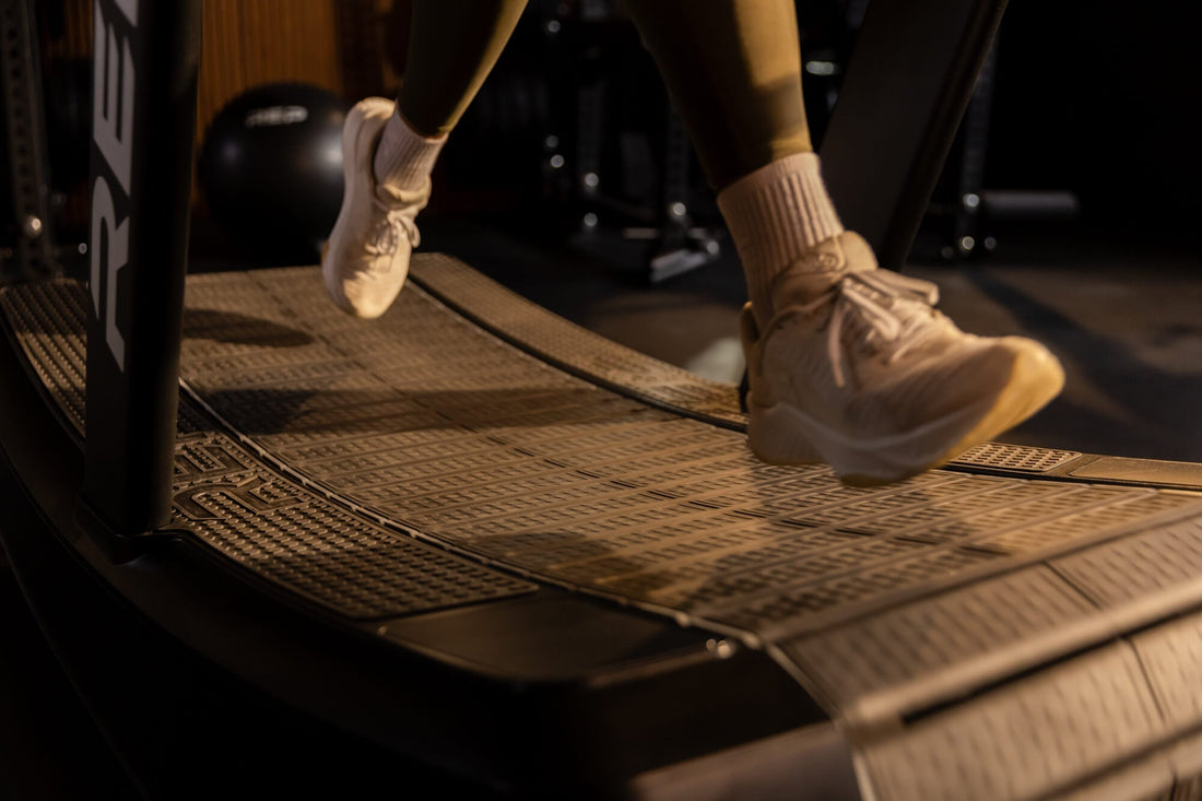 Close-up of feet running on the Strive™ Curved Treadmill.